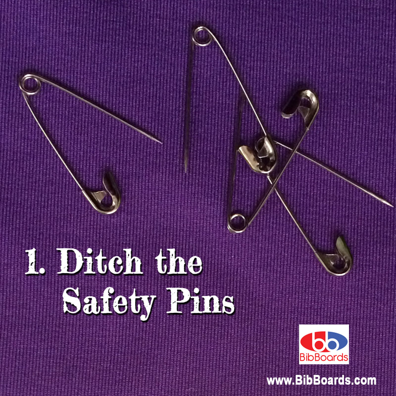 Four safety pins on purple background.