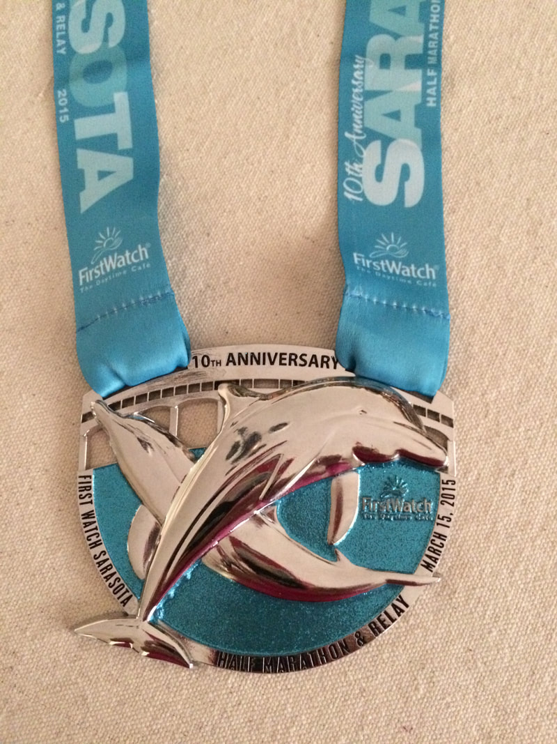 First Watch Sarasota Half Marathon 10th Anniversary Finisher Medal featuring huge dolphins.
