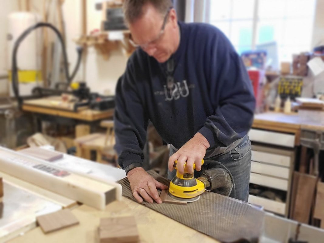 Joe V at Handcrafted Coaster sanding wood for custom made coasters.