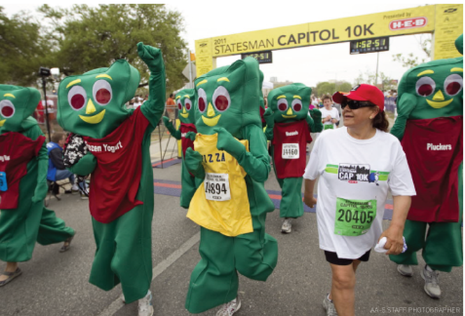 Runners dressed as Gumby cross finish line.