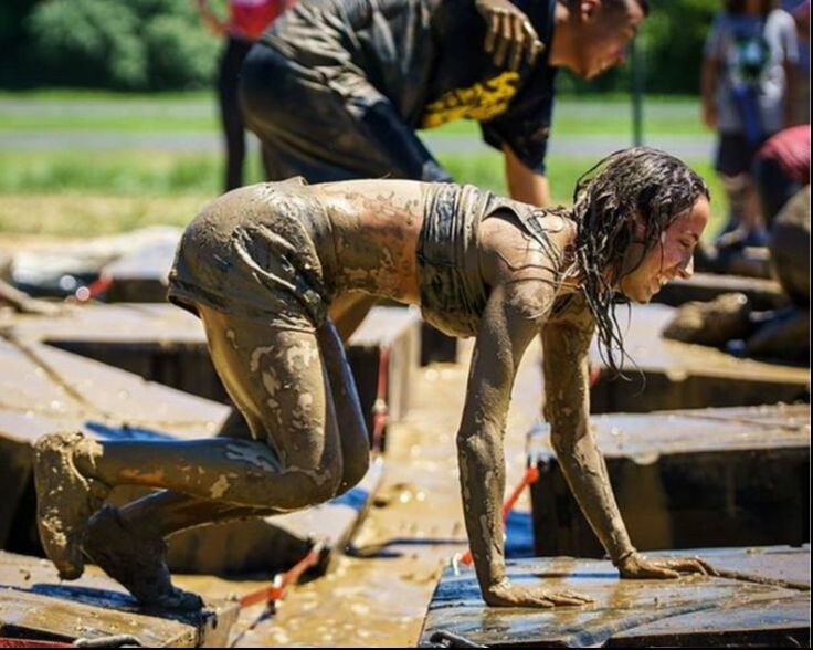 Girl covered in mud during a Rugged Maniac race.