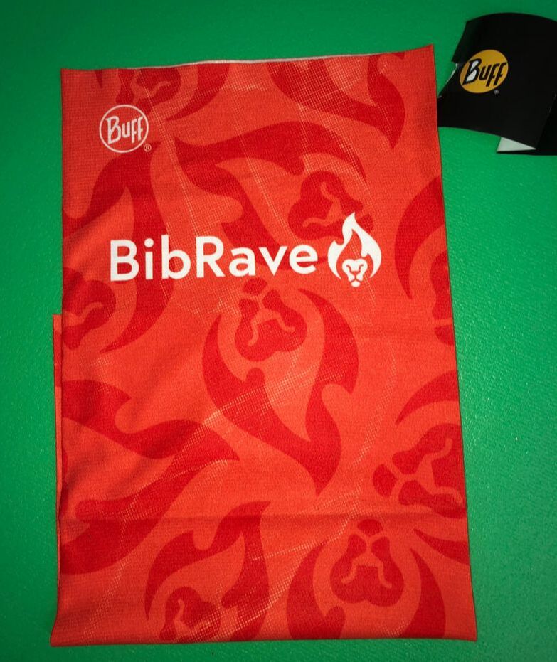 Photo of a BibRave classic Buff headwear in bright orange with the Bib Rave logo in white.