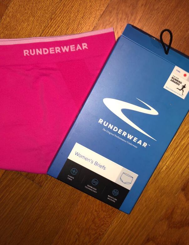 Photo of Runderwear pink briefs next to the box.