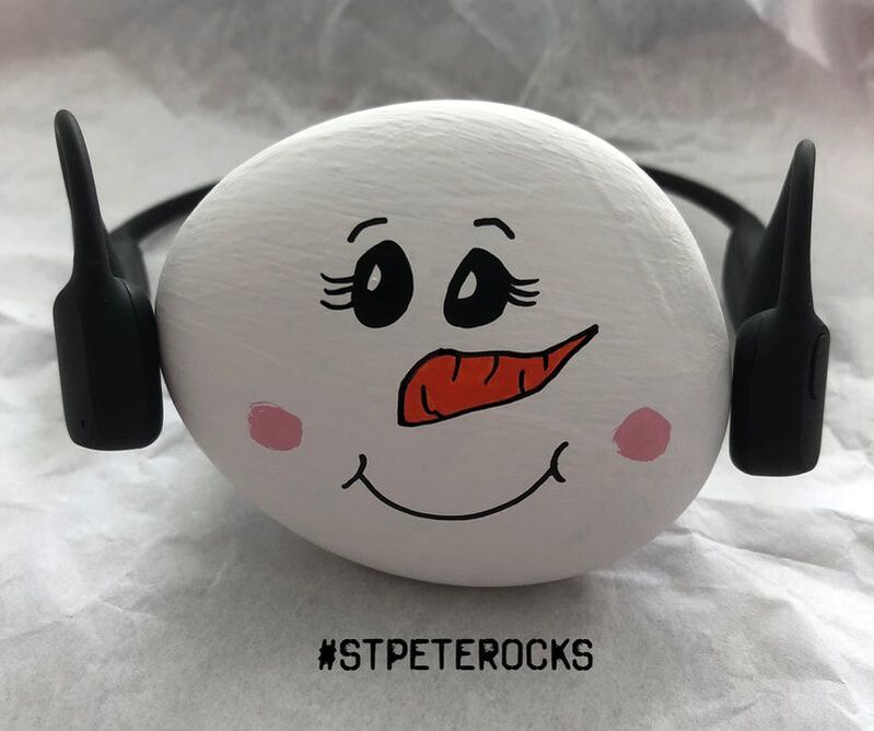 Rock painted like a snowgirl is wearing Aeropex bone conduction headphones.