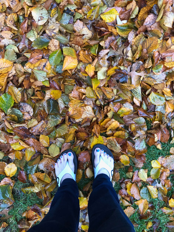 Wearing Oofos sandals in Fall leaves.