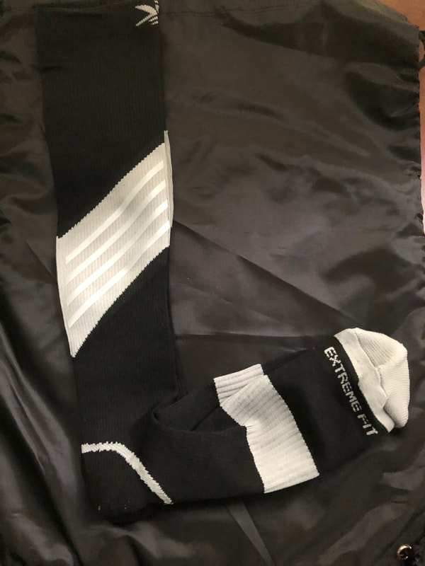 Photo of reflective compression socks. Black with gray stripes.