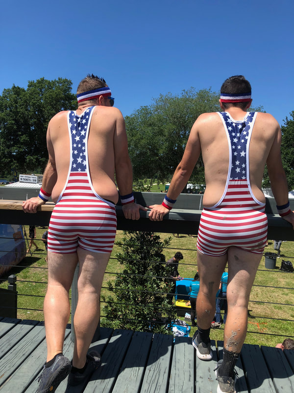 Two young men in patriotic wrestling outfits view the festival area at Rugged Maniac Dade City.