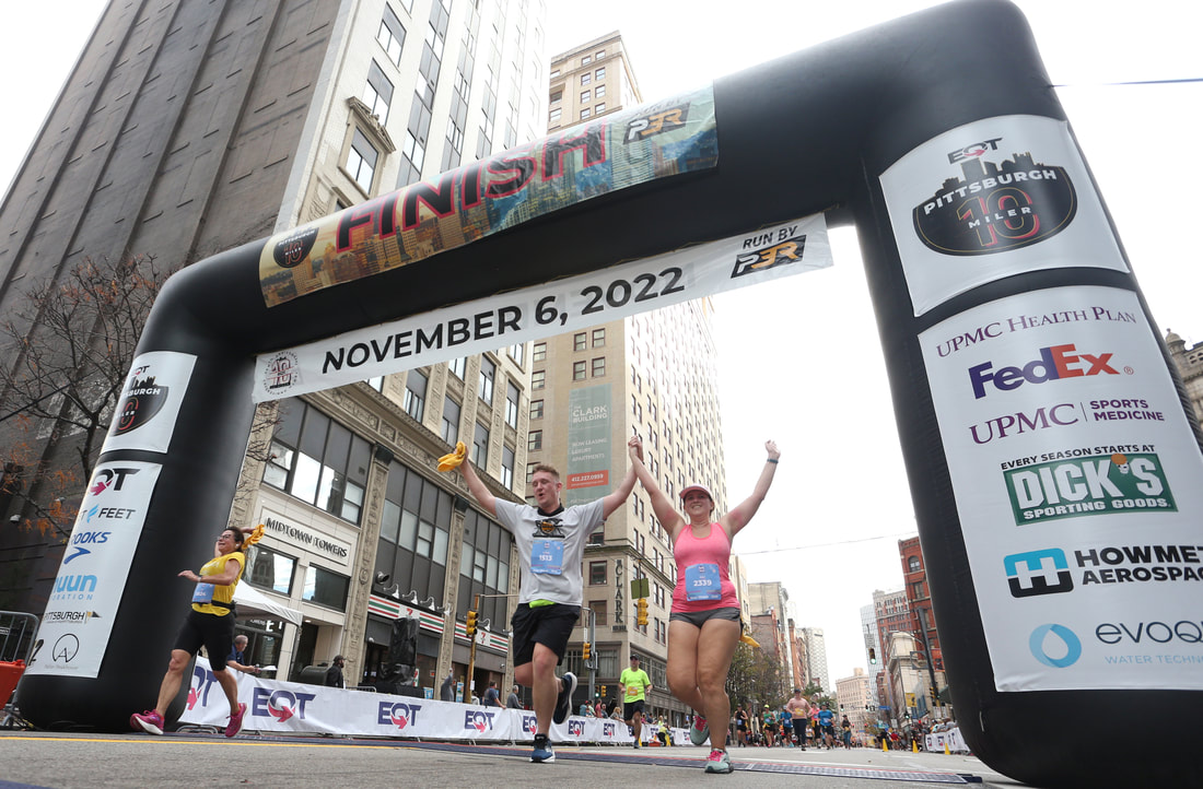 Runners crossing the finish line of the EQT Pittsburgh 10 Miler race.