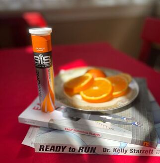 Tube of Science in Sport Immune Tablets next to books about running.