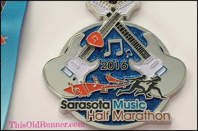 2016 Sarasota Music Half Marathon medal with guitar pick slider.